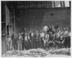 Lewis Hine child labor: Group of glass workers Shops 6 & 7, Illinois Glass Co. 12:45 P.M. Even the tiny chap on left end of photo was working. He is a Polish boy who cannot understand English. I saw him at work just before 1 P.M. Location: Alton, Illinois.