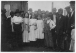 Lewis Hine child labor: Group of workers, including boys and girls, standing outdoors