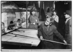 Lewis Hine child labor: Three years in the Glass House and no chance for promotion yet. Boy in foreground been "carry-in" since he was 14 years old. Wormser's Glass House. Location: Pittsburgh, Pennsylvania.